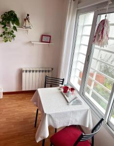 un comedor con una mesa blanca y una ventana en Habitación Hemerocallis - Hospedaje Lo De Juan y Mabel en Tandil