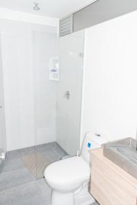 a bathroom with a white toilet and a shower at Apartamento Loft Edificio Soho 905 in Armenia