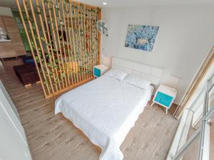um quarto com uma cama branca e duas mesas de cabeceira em Apartamento Loft Edificio Soho 905 em Armênia