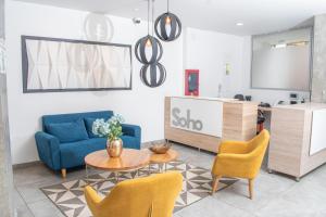 ein Wohnzimmer mit einem blauen Sofa, einem Tisch und Stühlen in der Unterkunft Apartamento Loft Edificio Soho 905 in Armenia