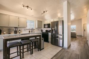 a kitchen with a refrigerator and a counter with bar stools at Casa Chiliwood in Albuquerque