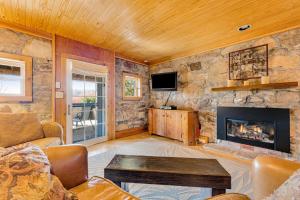 a living room with a stone wall with a fireplace at The Potato House in Banner Elk