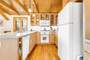 a kitchen with wooden cabinets and a white refrigerator at The Potato House in Banner Elk