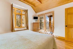 a bedroom with a large bed and two windows at The Potato House in Banner Elk