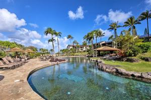 - une piscine dans un complexe avec des chaises et des palmiers dans l'établissement Hanalei Bay Resort 9206, à Princeville