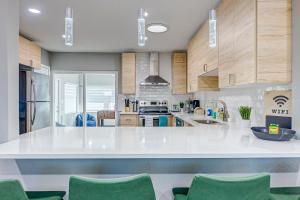 a kitchen with a large white counter and green chairs at Suwannee Lane in Cocoa Beach