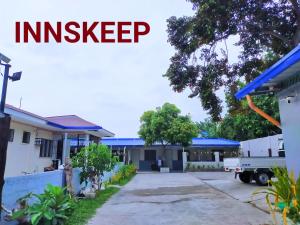 an empty driveway in front of a house with the words investep at Innskeep in Calingcuan