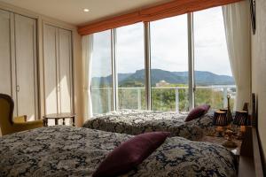 una camera d'albergo con due letti e una grande finestra di La Krasse Angelroad WEST a Tonosho