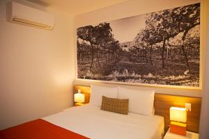 a bedroom with a bed with a painting on the wall at Partner Caxias do Sul in Caxias do Sul