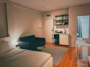 een slaapkamer met een bed, een bank en een tafel bij Oporto Batalha Nice View Flat in Porto