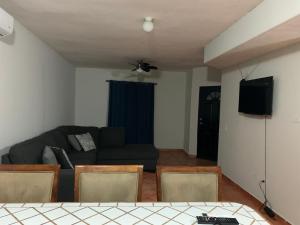 ein Wohnzimmer mit einem Sofa und einem TV in der Unterkunft Ariana’s house in Puerto Peñasco