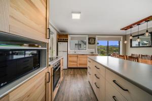 a kitchen with wooden cabinets and a large island at Petersdorf 2 Jindabyne Townhouse in Jindabyne
