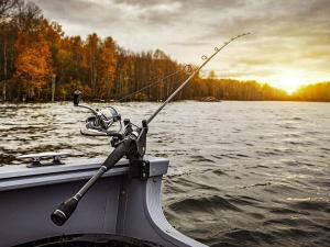 a boat with a fishing rod in the water at Holiday home MORA in Börka