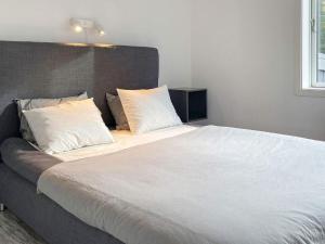 1 dormitorio con 1 cama grande con sábanas y almohadas blancas en Holiday home BORGHOLM XI, en Borgholm