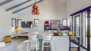 - une cuisine avec une table et des chaises dans la chambre dans l'établissement La Baie des Bambous SFX, à Saint-François