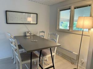 a dining room table with chairs and a lamp at Holiday home HJÄRNARP II in Hjärnarp