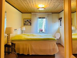 um quarto com uma cama com um edredão amarelo e uma janela em Holiday home MÖLLTORP em Mölltorp