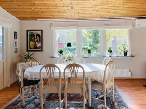 Holiday home MÖLLTORP في Mölltorp: غرفة طعام مع طاولة بيضاء وكراسي
