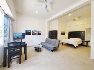 a room with a bed and a chair and a desk at Quinta Suites in Cozumel