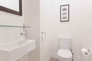 ein weißes Badezimmer mit Toilette und Waschbecken in der Unterkunft Dutchies Haven, 11 Christmas Bush Ave - Pet friendly, large enclosed yard, air con and Wi-Fi in Nelson Bay + 14 Fotos