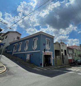 un edificio azul al lado de una calle en Pousada Casa de Bragança II, en Bragança Paulista