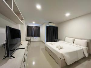 1 dormitorio con 1 cama y TV de pantalla plana en Donmueang Place Hotel - SHA Plus, en Bangkok