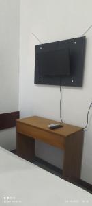 a wooden table with a television on a wall at Hotel Foz Brasil in Foz do Iguaçu