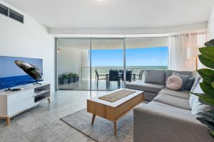 a living room with a couch and a table at Sirocco 906 in Mooloolaba