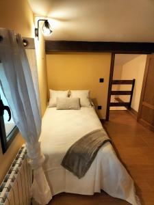 ein weißes Bett in einem Zimmer mit Fenster in der Unterkunft Casita Merrick in Arenas de San Pedro