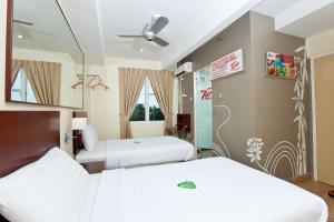 a hotel room with two beds and a mirror at Tune Hotel Georgetown Penang in George Town
