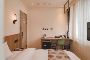 a hotel room with a bed and a desk at East Town 26 Hotel in Hualien City