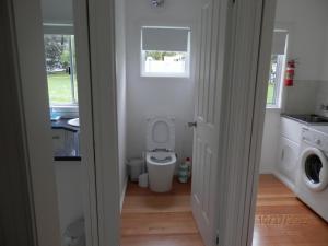 a small bathroom with a toilet and a window at A Slice of Paradise in Barnes Bay