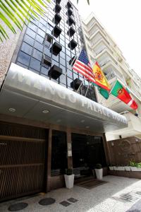 a facade of a building with flags in front of it at Mengo Palace Hotel in Rio de Janeiro