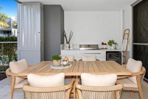una cucina e una sala da pranzo con tavolo e sedie in legno di Drift North Apartments by Kingscliff Accommodation a Casuarina