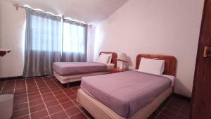 a room with two beds and a window with at Hotel La Rinconada Tequisquiapan in Tequisquiapan +21 photos