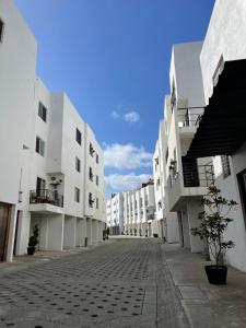 an empty street with white buildings on either side at Casa Luna 2 bedroom Condo 5 min to Border & Beach in Tijuana