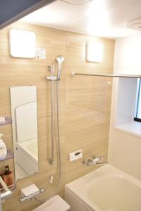 a bathroom with a shower and a toilet and a sink at Hiroshima Danbara LiBPLUS in Hiroshima +29 photos