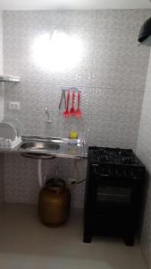 a small kitchen with a stove and a sink at KITNET EM OLINDA CASA CAIADA A 50 MT DA PRAIA in Olinda