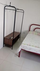 a bedroom with a bed and a wooden table at KITNET EM OLINDA CASA CAIADA A 50 MT DA PRAIA in Olinda +15 photos