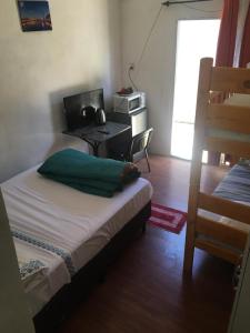 a bedroom with a bed and a desk with a computer at N1-3 Apto Céntrico Pequeño Habitación C/ Aire Acondicionado P/4 Personas Baño Privado in Artigas