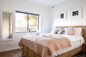 een slaapkamer met een groot bed met een raam bij Manly Cosy Retreat - Short walk to beach in Sydney