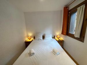 a bedroom with a bed with two candles on it at Appartement Méribel, 2 pièces, 4 personnes - FR-1-688-40 in Méribel