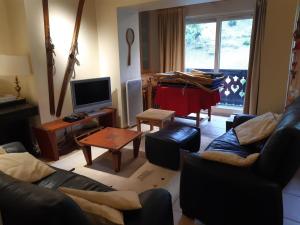 a living room with a couch and a tv at Appartement Courchevel 1550, 3 pièces, 6 personnes - FR-1-514-74 in Courchevel