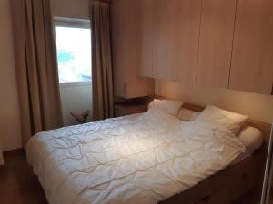a bedroom with a white bed with a window at Appartement Courchevel 1550, 3 pièces, 6 personnes - FR-1-514-74 in Courchevel