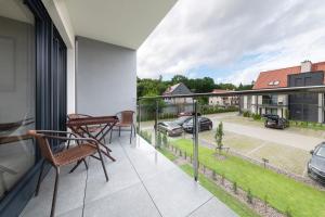 a balcony with chairs and a view of a street at Baltique Apartment in Niechorze