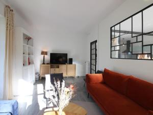 a living room with a couch and a tv at Maison La Bourboule, 5 pièces, 9 personnes - FR-1-608-237 in La Bourboule