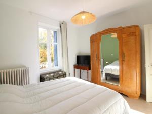 - une chambre avec un grand lit blanc et un miroir dans l'établissement Maison La Bourboule, 5 pièces, 9 personnes - FR-1-608-237, à La Bourboule