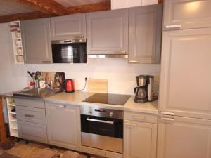 a kitchen with white cabinets and a stove top oven at Spacieux appartement 5 pièces près des pistes, jusqu'à 12 personnes, parking et balcons - FR-1-411-851 in Landry +5 photos
