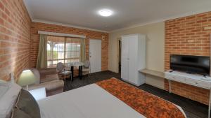 a living room with a brick wall at Country Gardens Motor Inn in Cowra