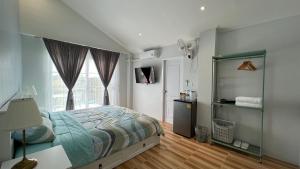 a bedroom with a bed and a window at Cozy life ไออุ่น in Khao Kho